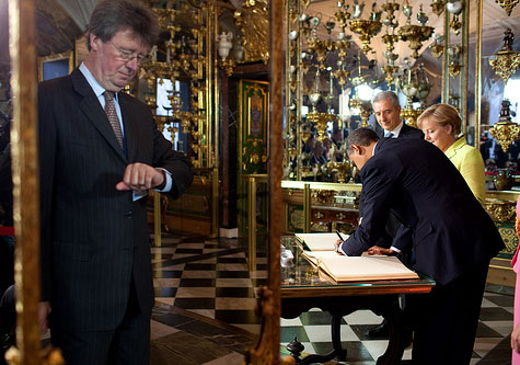 Obama signs guest book while Angela Merkel waits 
