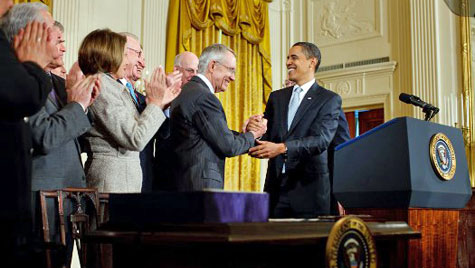 President Obama demonstrates his strong death grip handshake on Harry Reid